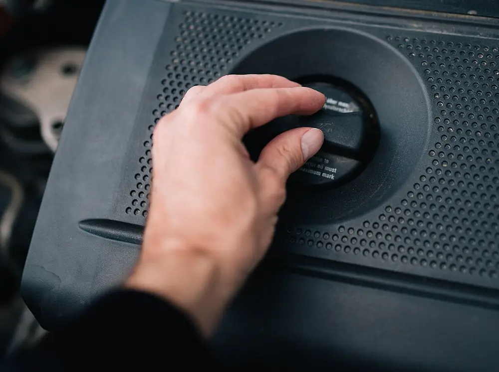 Opening the oil cap on an engine